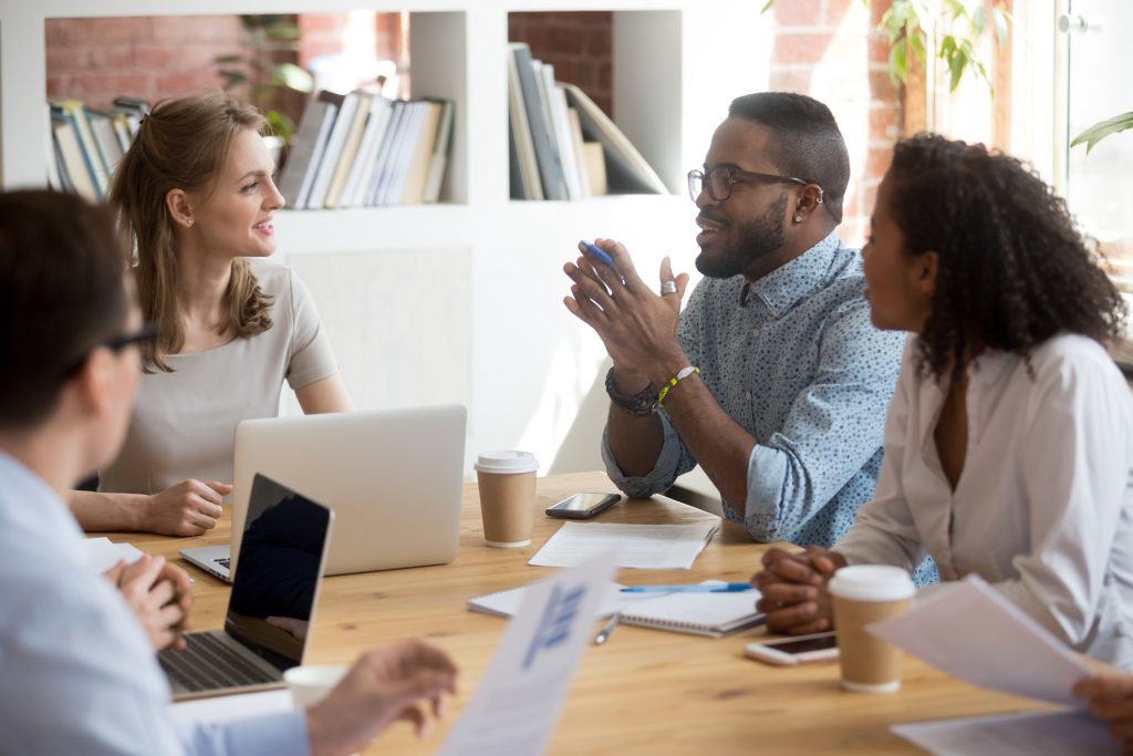 employees speaking sharing ideas at team meeting
